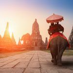 Tourists With an Elephant at Wat Chaiwatthanaram temple in Ayutthaya Historical Park, a UNESCO world heritage site in Thailand