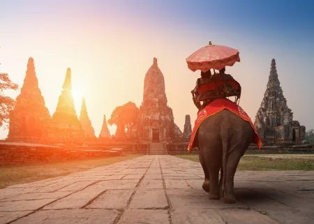Tourists With an Elephant at Wat Chaiwatthanaram temple in Ayutthaya Historical Park, a UNESCO world heritage site in Thailand