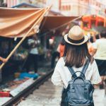 Young asian woman traveler visiting in Maeklong railway market is the most famous traditional traditional market unseen in Thailand at Maeklong district in Samut Songkhram near Bangkok Tha