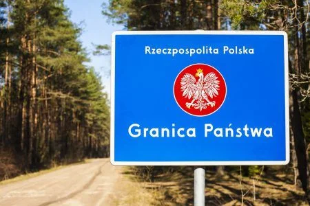 Border with emblem of the Poland. Road and forest in background.