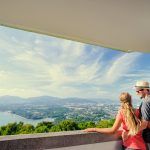 Tourist attraction. Couple of travelers enjoying sea, city and sky on the view point.