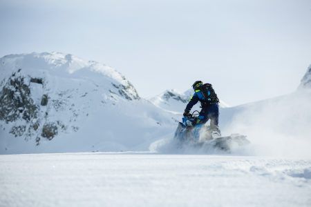 A Person Riding A Snowmobile In Winter