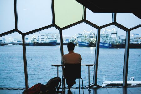 A man sitting and looking at the view from the Harpa Concert Hall, Reykjavik, Iceland
