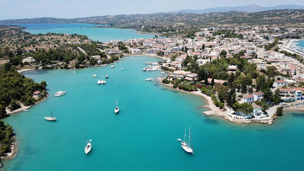 Aerial drone bird’s eye view photo of famous and picturesque yacht dock seaside fjord village of Porto Heli with turquoise and emerald clear waters, Argolida, Peloponnese, Greec