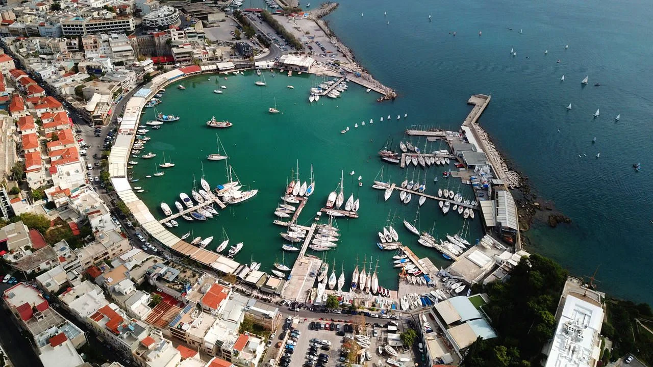 Aerial drone bird’s eye view photo of iconic round shaped picturesque port of Mikrolimano with sail boats and yachts docked and beautiful colours, Piraeus port, Attica, Greece
