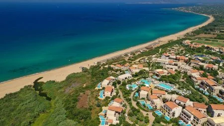 Aerial drone panoramic photo of famous sandy deep turquoise – blue exotic beach and famous luxury paradise resort of Costa Navarino in Messinia, Peloponnese, Greece