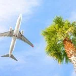 Airplane Is Flying In Cloudy Sky Over Island And Sea In Summer At Seychelles