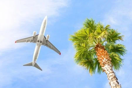 Airplane Is Flying In Cloudy Sky Over Island And Sea In Summer At Seychelles