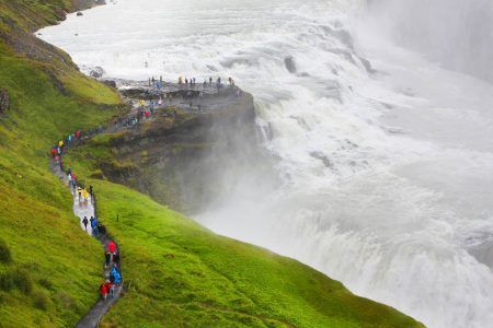 Cascades of Gullfoss waterfall with tiny people looking at the water masses, Golden circle, Iceland