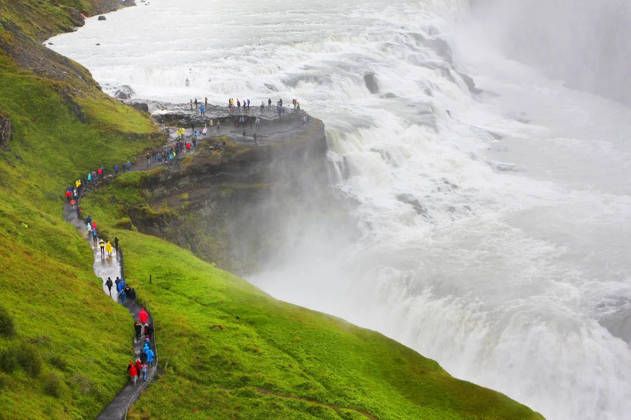 Cascades of Gullfoss waterfall with tiny people looking at the water masses, Golden circle, Iceland