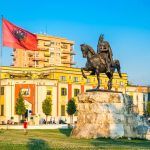 Skanderbeg square with flag, Skanderbeg monument and The Et’hem Bey Mosque in the center of Tirana city, Albania.