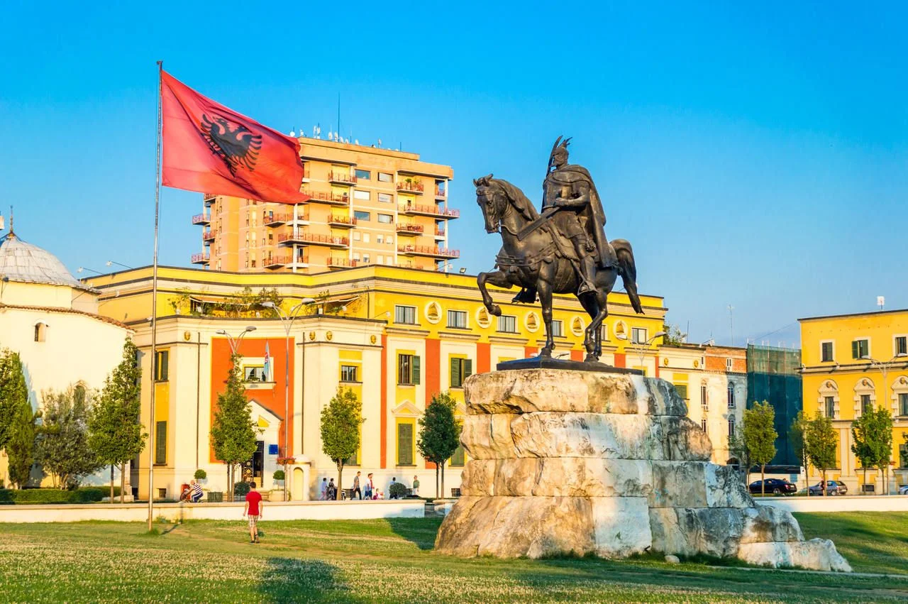 Skanderbeg square with flag, Skanderbeg monument and The Et’hem Bey Mosque in the center of Tirana city, Albania.