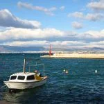 Small fishing boat anchored in the port of Sutivan, on island Brac, Croatia. Split seen in the background. Selective focus.