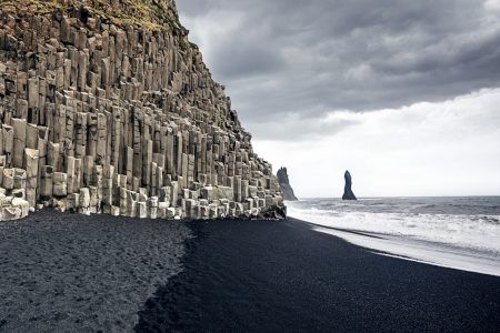 The black sand beach of Reynisfjara and Mount Reynisfjall from the Dyrholaey headland on the south coast of Iceland.