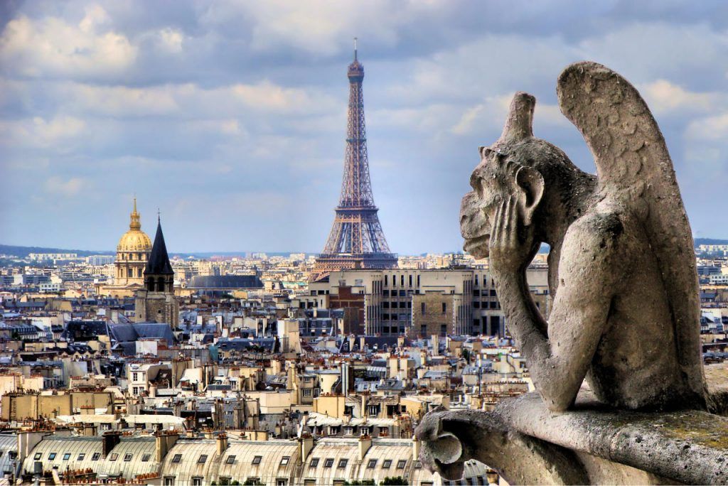 The famous Notre Dame gargoyle overlooking the Parisian landscape with the Eiffel Tower