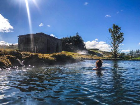 Woman swimming in natural thermal pool in fludir secret lagoon