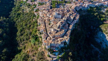 Aerial view of the horseshoe shaped narrow streets of Tourrettes sur Loup, a stone village built on a promontory in the mountains above Nice on the French Riviera, France