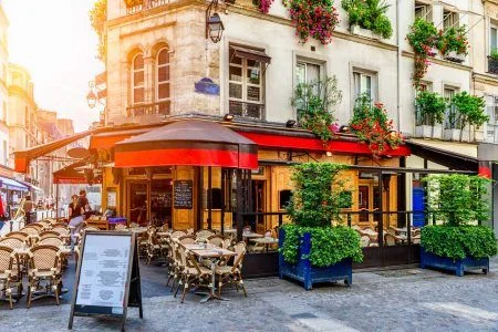Cozy street with cafe tables in Paris, France. Architecture and Paris landmark. Cozy Parisian landscape.