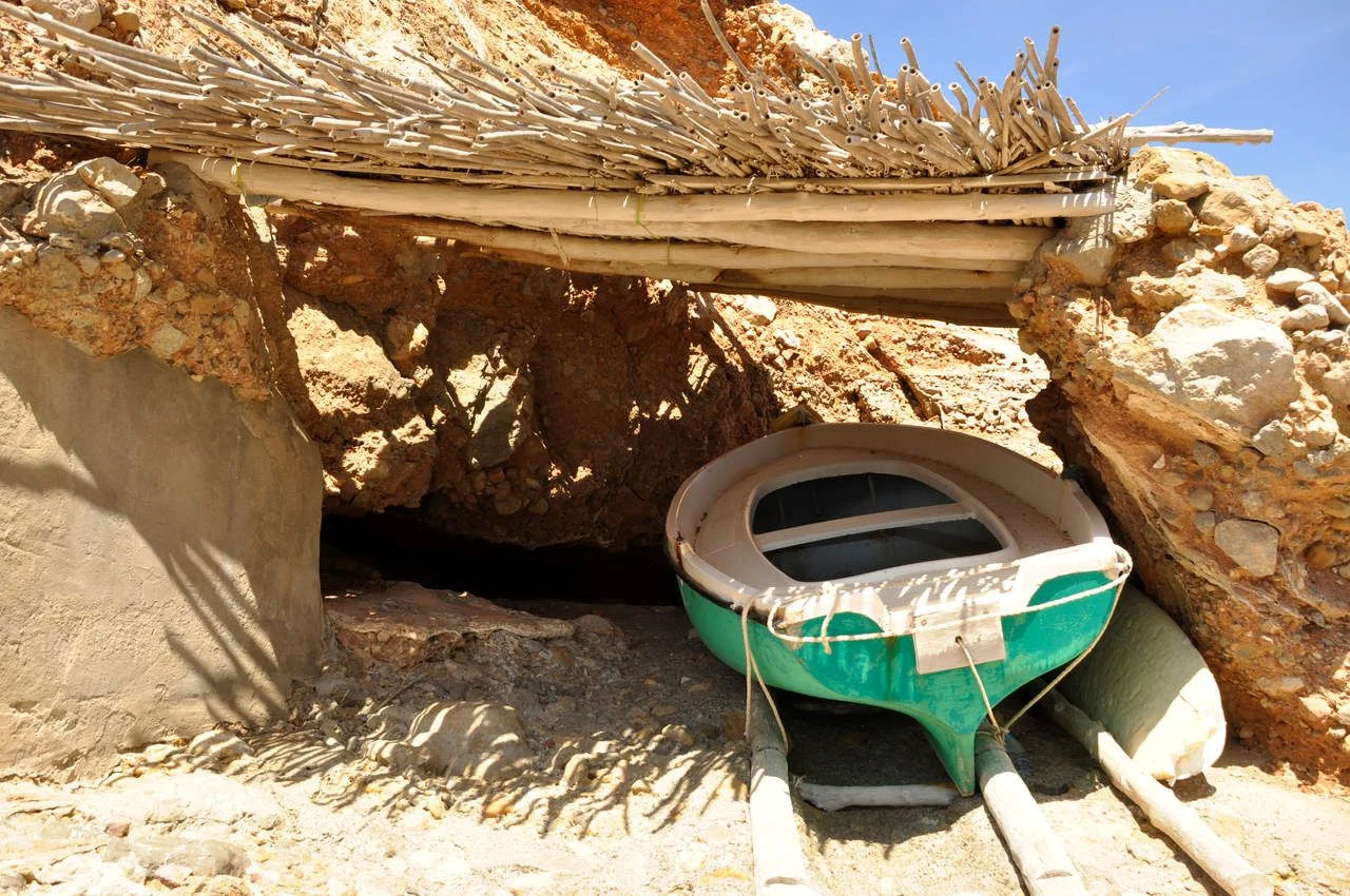 Fisherman boat under the shadow local tradition beautiful scenery old bay on the rocks shelter under the bright sun Ibiza island