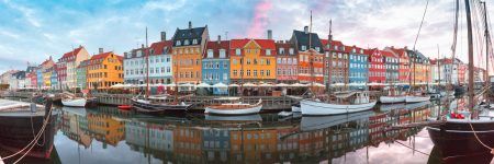 Nyhavn at sunrise, with colorful facades of old houses and old ships in the Old Town of Copenhagen, the capital of Denmark.