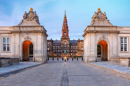 The main entrance to Christiansborg with the two Rococo pavilions on each side of the Marble Bridge during morning blue hour, Copenhagen, capital of Denmark