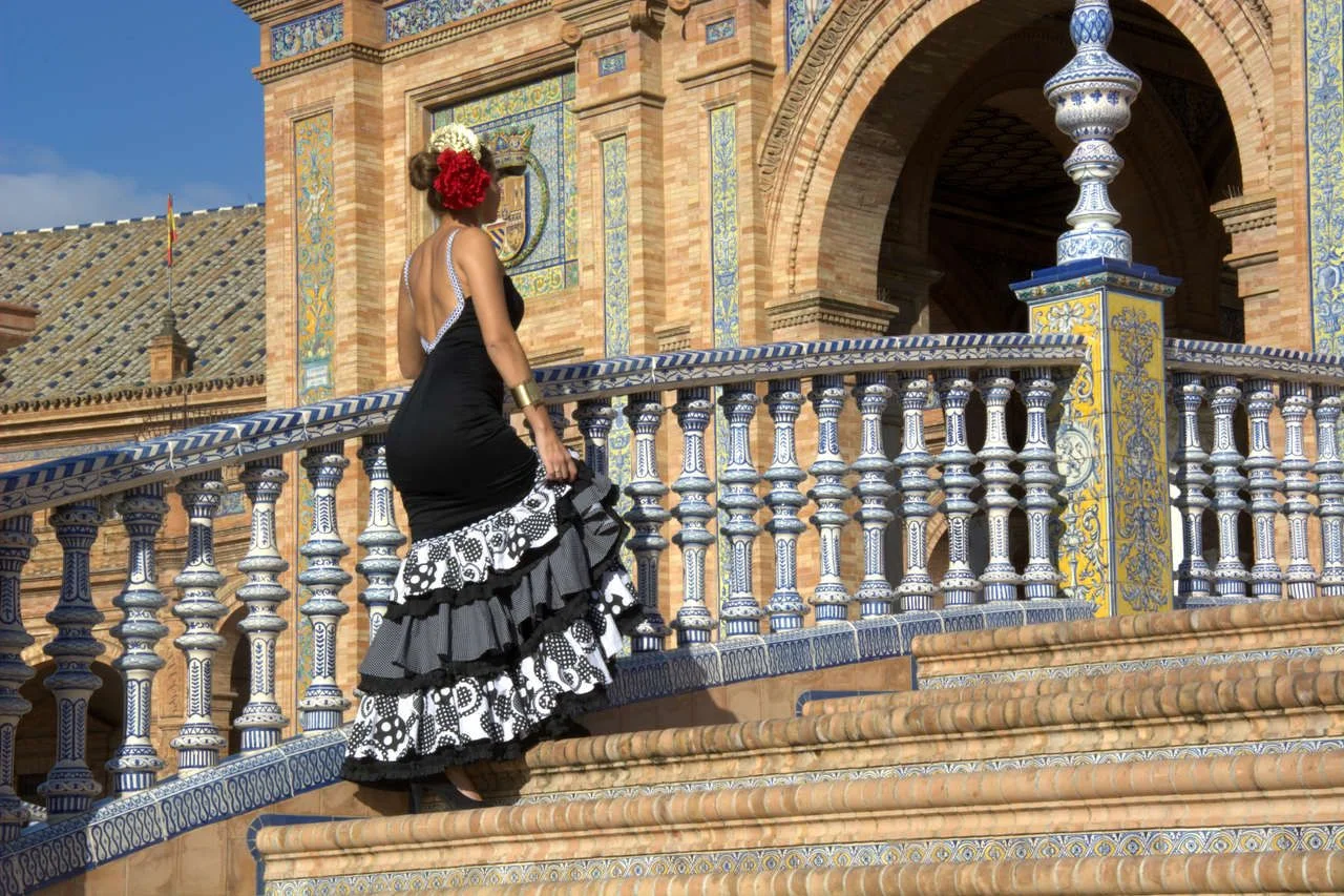 Woman with flamenco dress climbing the stairs to Spain square