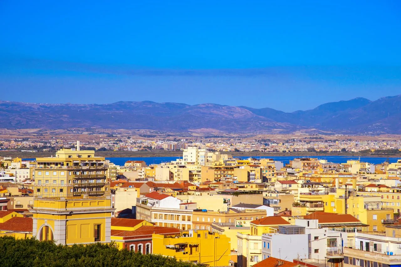 an aerial view of Cagliari, in Sardinia, Italy, with the Montelargius lake and Quartu Sant Elena in the background