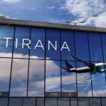 Jet aircraft landing at Tirana, Albania 3D rendering illustration. Arrival in the city with the glass airport terminal and reflection of the plane. Travel, business, tourism and transport concept.