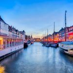 Nyhavn with a picturesque harbor with old sailing ships and colorful facades of old houses in Copenhagen, Denmark.