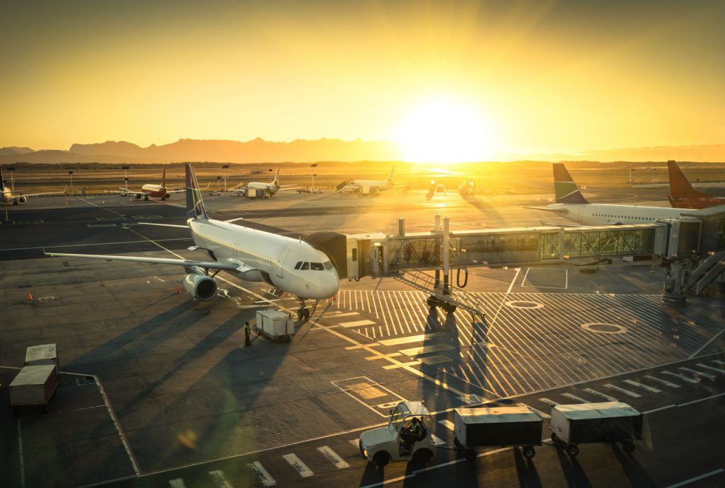 Plane at the terminal gate ready for take off – Modern international airport during sunset – Concept of emotional travel around the world