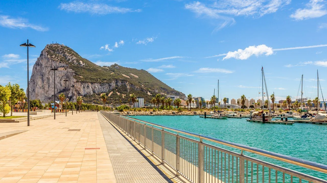 Road to the Rock of Gibraltar with marina on the left and town behind, view from La Linea, Spain