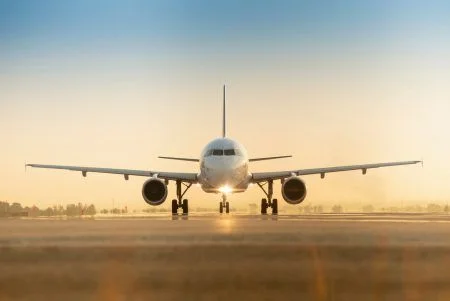 Sunset view of airplane on airport runway under dramatic sky