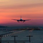 a passenger plane lands on the airport runway early in the morning at sunrise in the freezing winter air