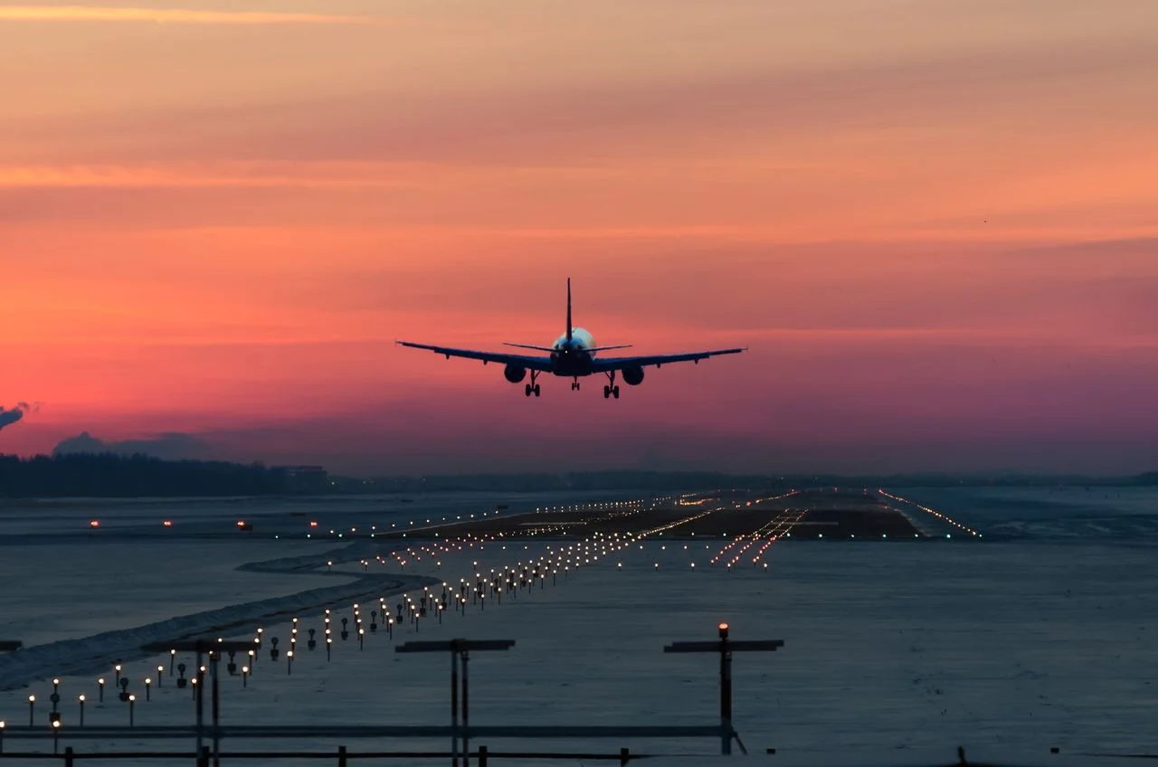 a passenger plane lands on the airport runway early in the morning at sunrise in the freezing winter air