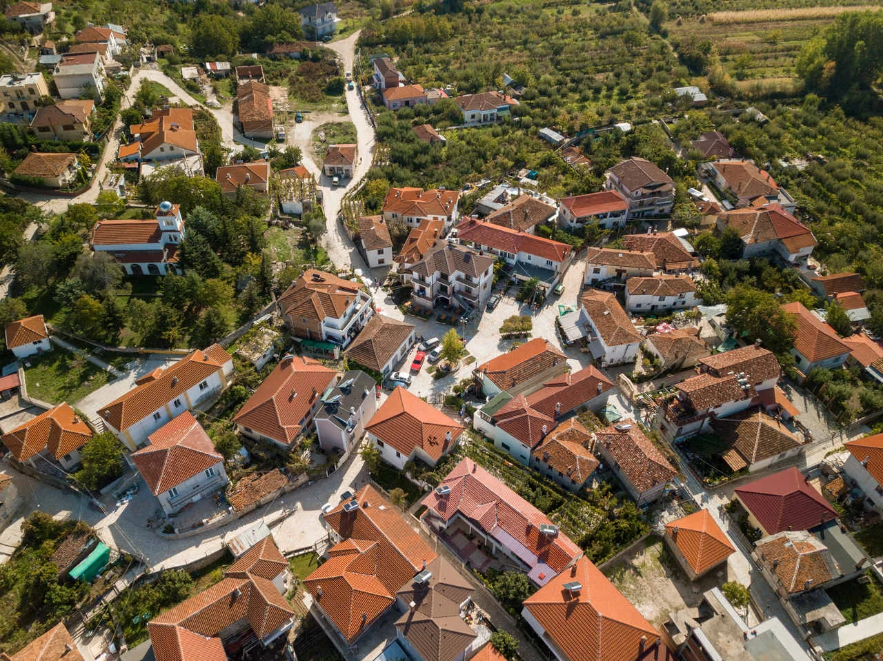 aerial picture taken with a drone of the small village of Tushemisht on Pogradec, east of Albania. on the photo you can see the village from above and the houses with orange rooftops