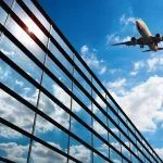 glass curtain wall and plane against a blue sky