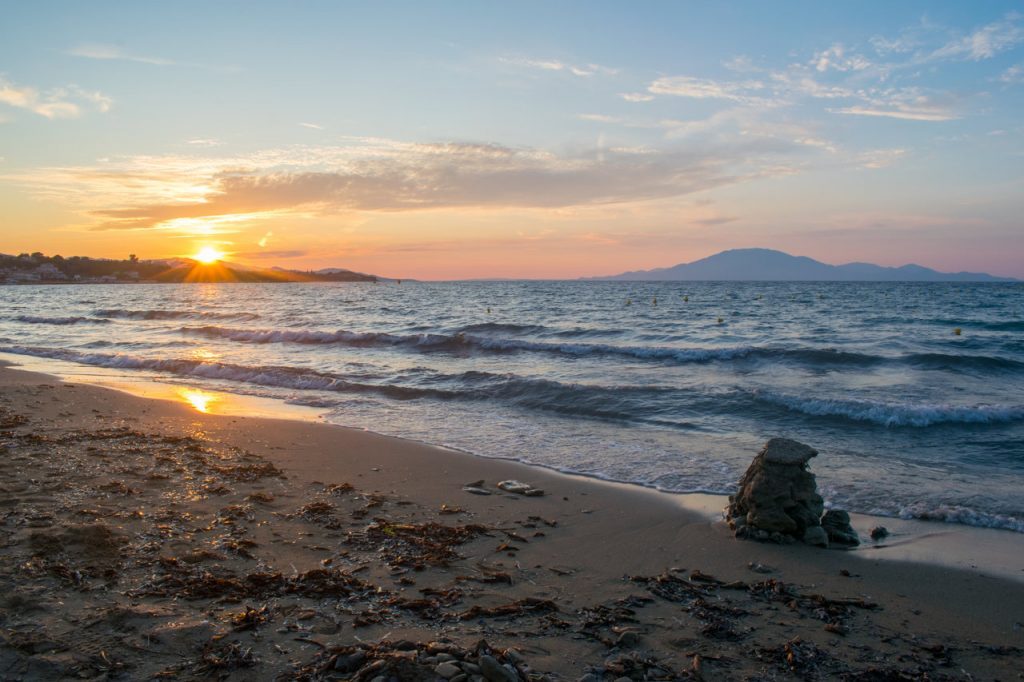 A beautiful sunset at Tsilivi beach on the Greek island of Zakynthos, with the Ionian sea and Mount Ainos, the tallest peak of Kefalonia island in the background
