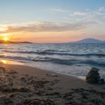 A beautiful sunset at Tsilivi beach on the Greek island of Zakynthos, with the Ionian sea and Mount Ainos, the tallest peak of Kefalonia island in the background