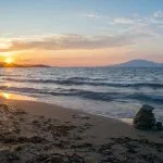 A beautiful sunset at Tsilivi beach on the Greek island of Zakynthos, with the Ionian sea and Mount Ainos, the tallest peak of Kefalonia island in the background