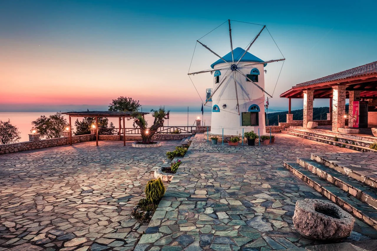 A bewitching sight of the Potamitis windmill in the morning. Colorful spring sunrise in Zakynthos island, Korithi location, Ionian Sea, Greece, Europe. Rural beauty concept background.