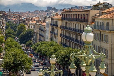 Marseille, France. View to the city from the main staircase of the central railway station Gare de Marseille-Saint-Charles, retro street lamps in the foreground. Travel France.