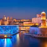 Marseille Old Port and Fort Saint-Jean and Museum of European and Mediterranean Civilisations and Marseille Cathedral illumintaed in night. Marseille, France. Marseille, France. Horizontal camera pan