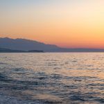 Sunset in the beach of Aegeian sea in Adelianos Kampos resort, Crete island, Greece