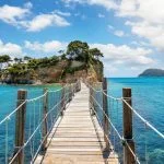The wooden footbridge leading to the small island of Agios Sostis on Zakynthos, Greece, during a sunny summer day