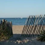 View on white sandy beach Les Sablettes in La Seyne-sur-mer in morning sunlights