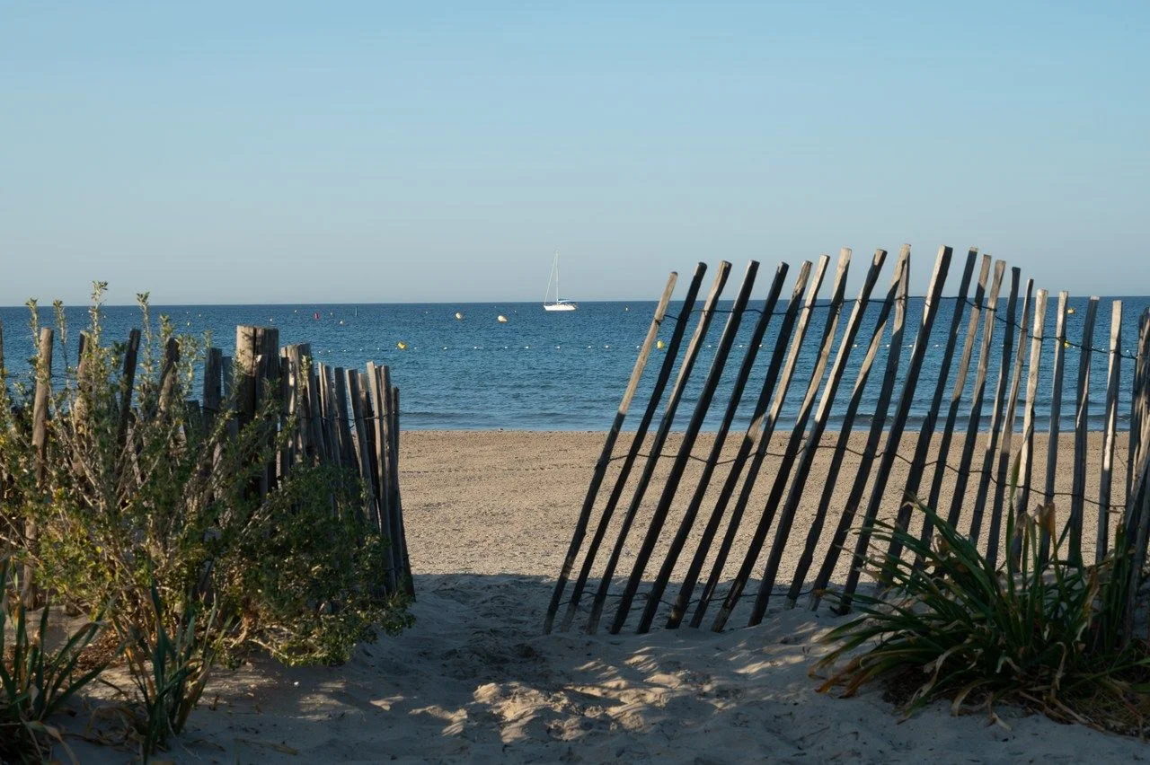 View on white sandy beach Les Sablettes in La Seyne-sur-mer in morning sunlights
