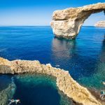 Azure window on the island of Gozo – Mediterranean natural wonder in beautiful Malta – Unrecognizable tourist divers – world famous rock formation collapsed after a sea storm