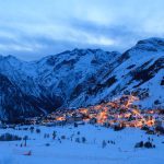 Photo of France ski resort Les Deux Alpes at the evening. You can see a part of resort with many mountains around it.