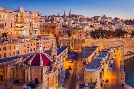 Valletta, Malta – Traditional houses and walls of Valletta, Malta’s capital city in the early summer morning before sunrise with a bright blue sky
