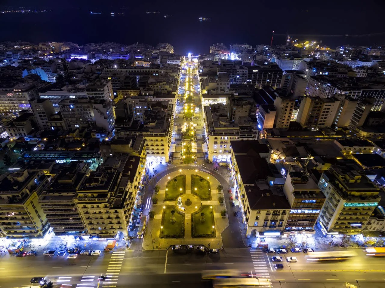 Aerial view of Aristotelous Square and the northern Greek city Thessaloniki at night. Image taken with action drone camera causing distortion and blur.